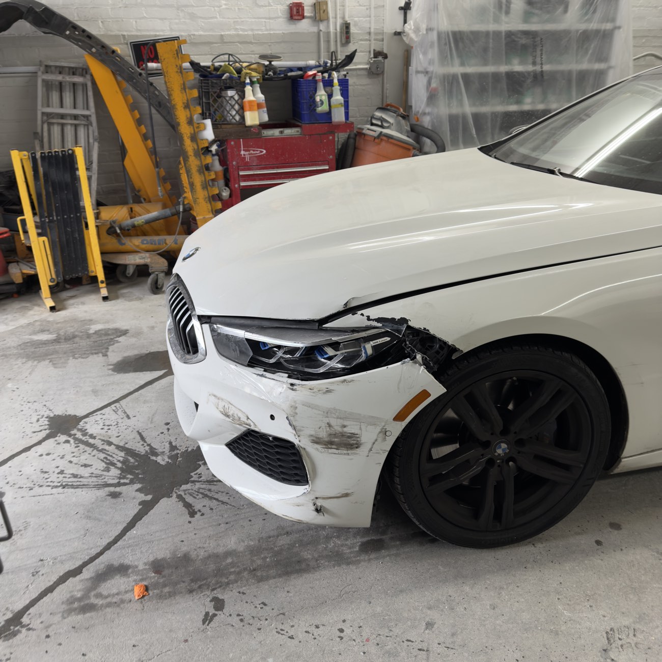 White BMW 8 Series with front bumper and fender collision damage before auto body repair at Exclusive Collision & Repair in Brooklyn, NY