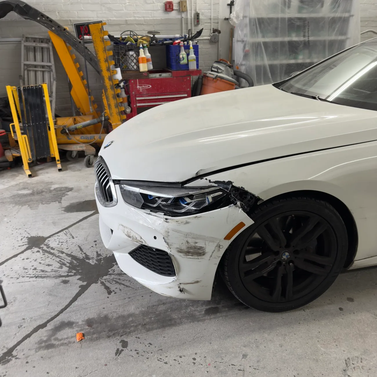 White BMW 8 Series with front bumper and fender collision damage before auto body repair at Exclusive Collision & Repair in Brooklyn, NY