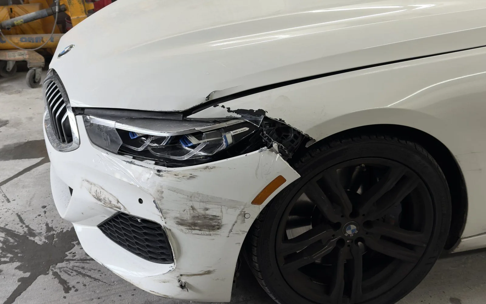 White BMW 8 Series with a crushed front bumper and fender before repair at Exclusive Collision & Repair in Brooklyn, NY