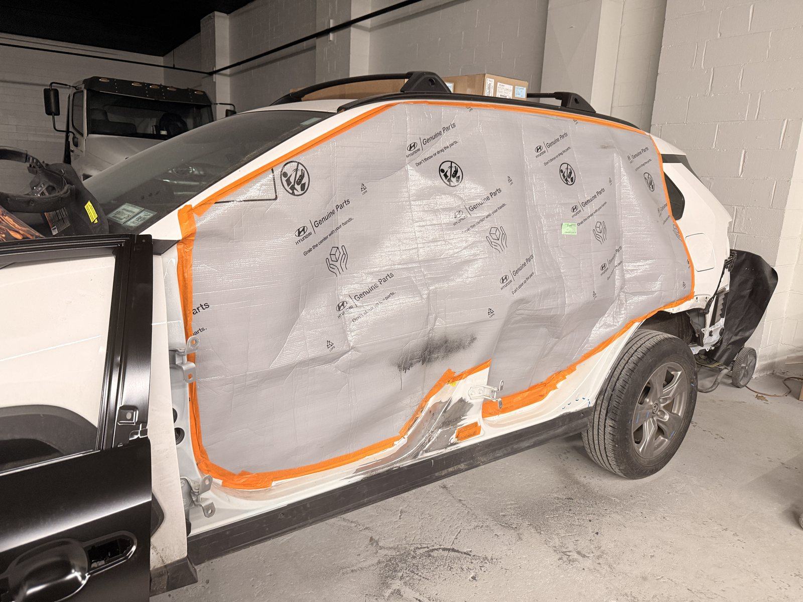 SUV masked off and prepped for refinishing inside the heated spray booth at Exclusive Collision & Repair auto body shop in Brooklyn, NY
